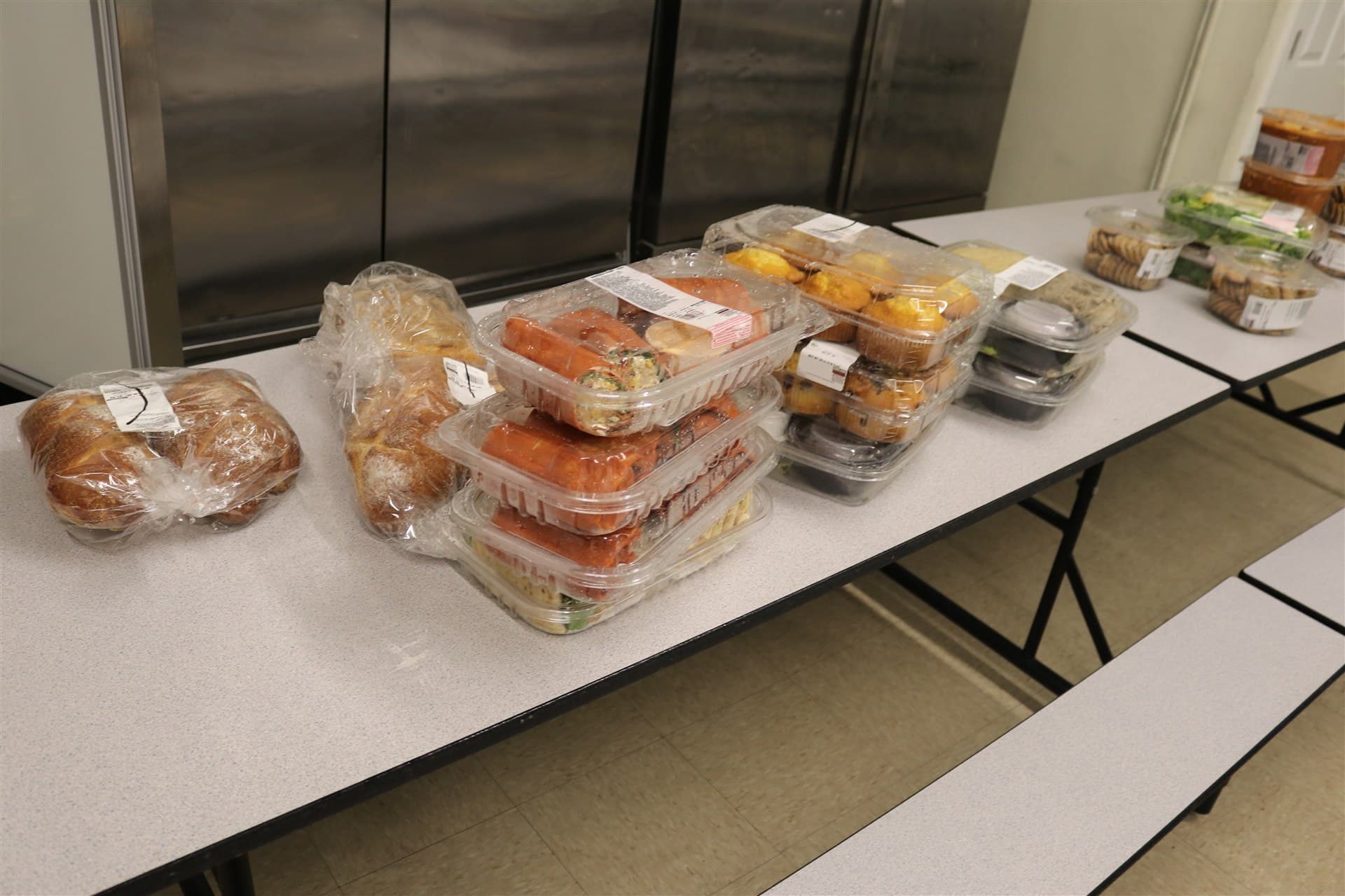 Rows of prepared meals organized on tables for HESM food outreach in Boston