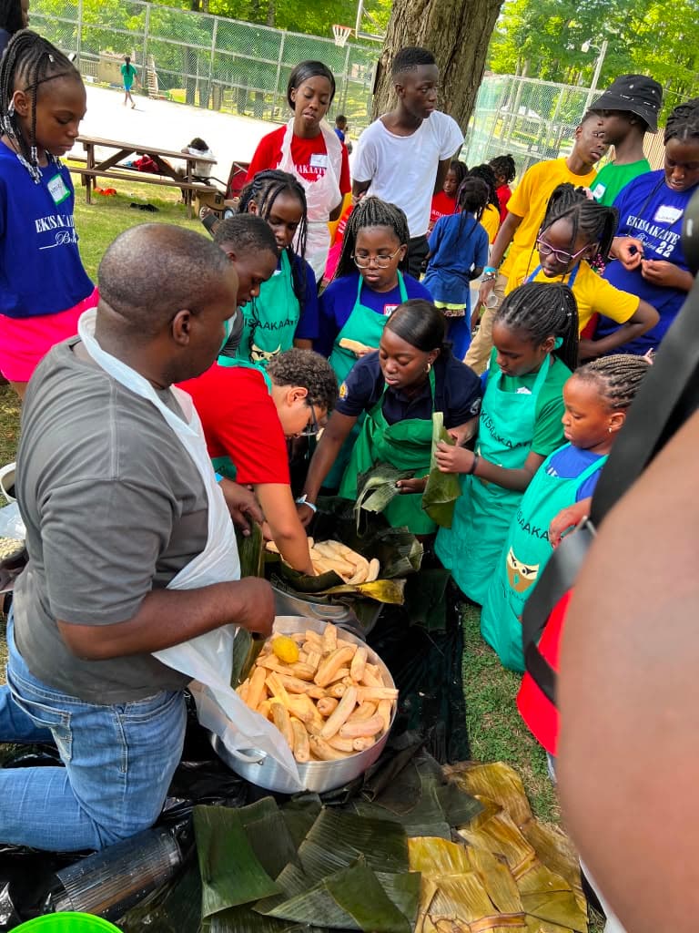 Young people wrapping food in banana leaves during an Ekisaakaate Boston cooking session